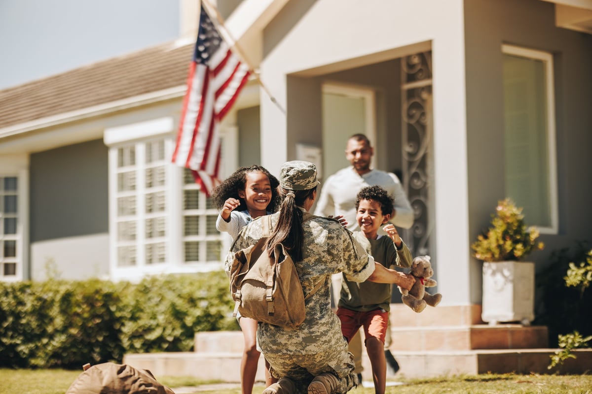 A veteran reuniting with her family in a warm and welcoming home, reflecting inclusive community housing