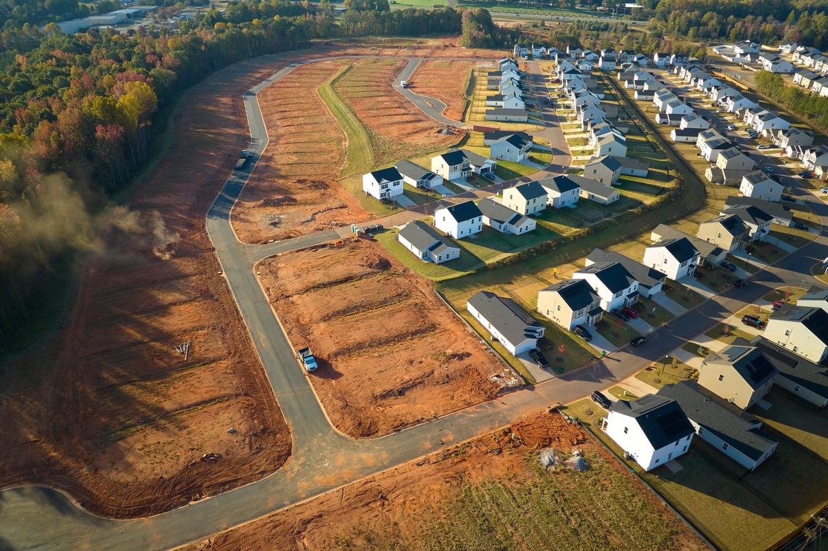 Wide aerial view of an active residential subdivision under construction, with homes and infrastructure taking shape across the development